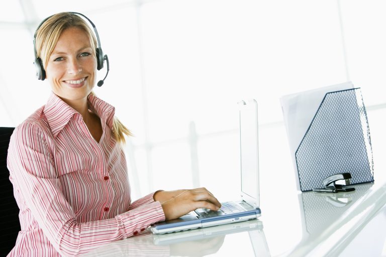 Businesswoman using headset and laptop